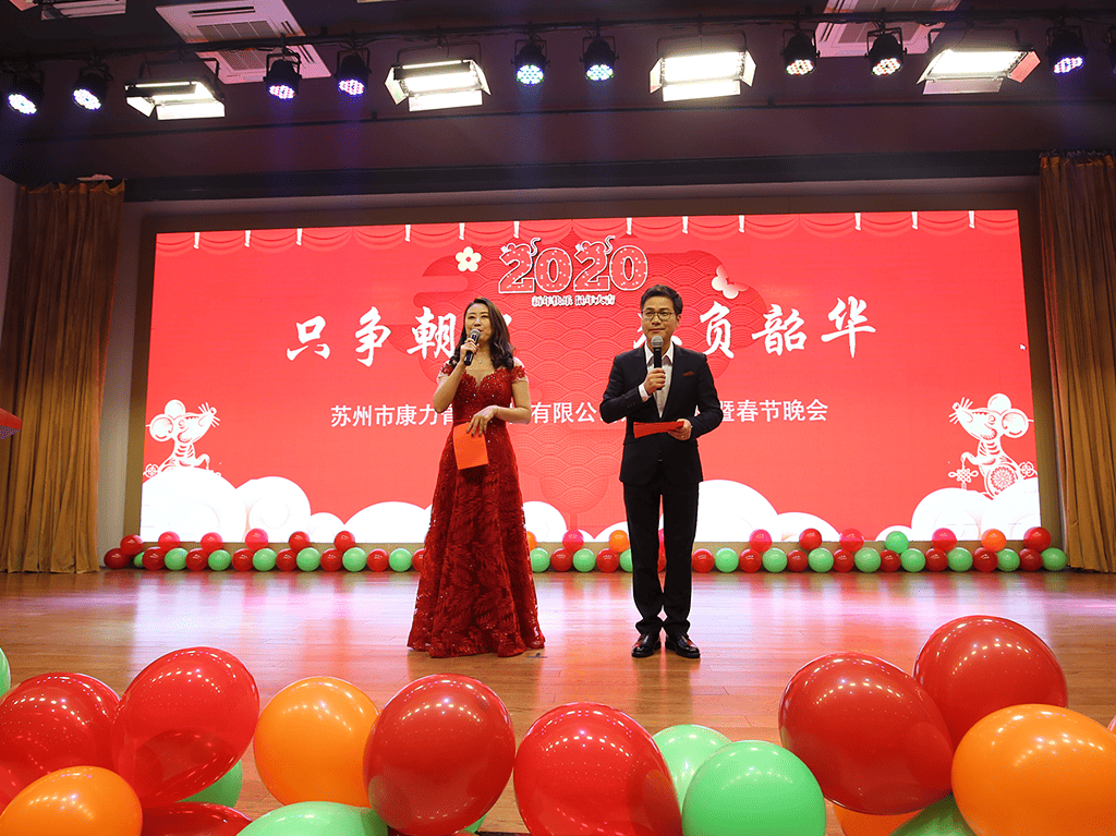 A male and a female host standing on the stage, hosting the annual gala event.